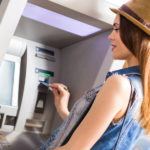Young woman withdrawing money at the ATM